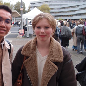 Al (23) und Anna (19) auf dem Campus am Albertus-Magnus-Platz. Beide studieren Psychologie und nahmen an der offiziellen Begrüßung der Erstsemester in der großen Aula der Uni Köln teil.
