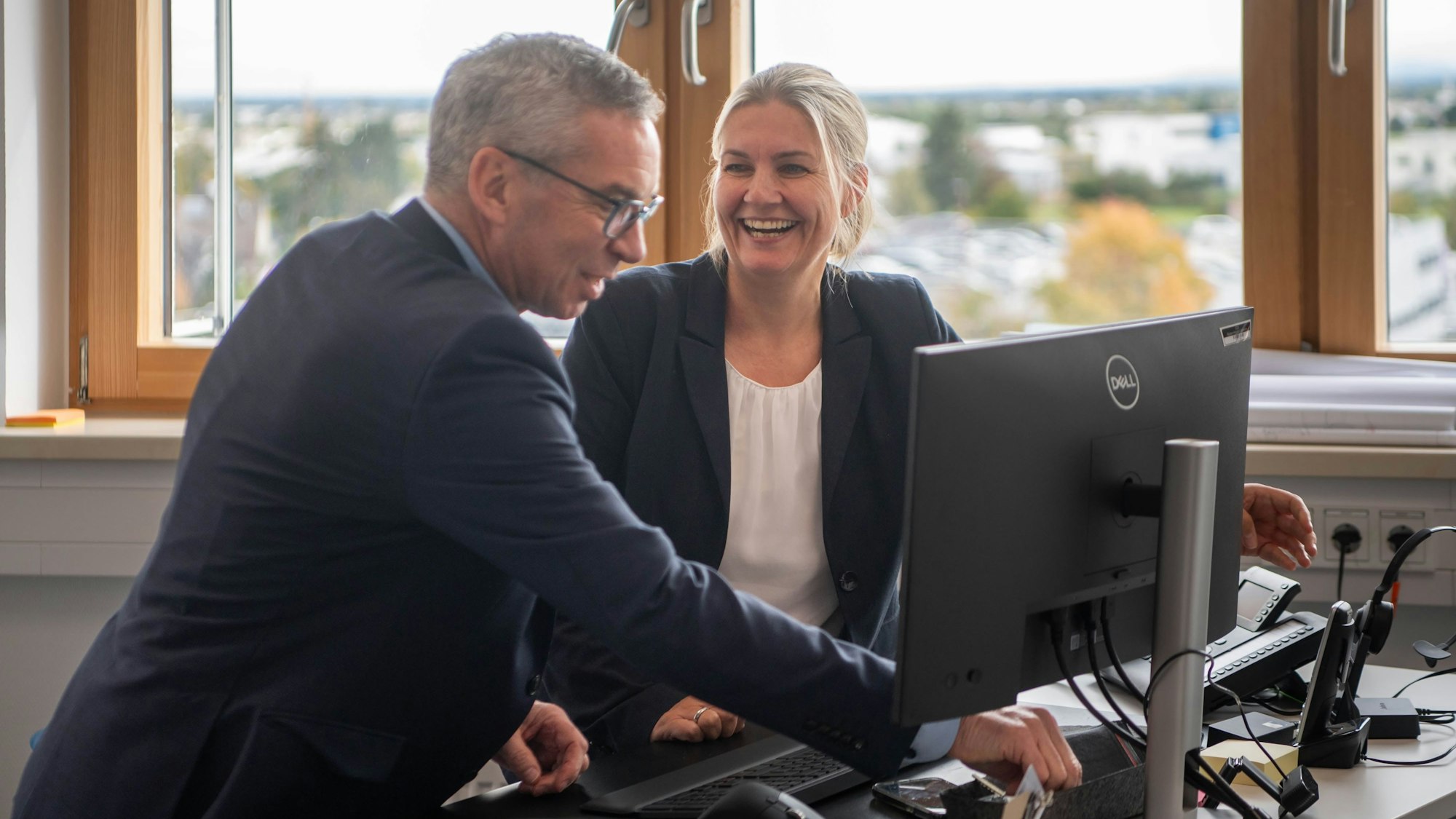Das Bild zeigt Dr. Maren Thäter und Wolfgang Schneider gemeinsam hinter einem Schreibtisch. Sie sind bester Laune.