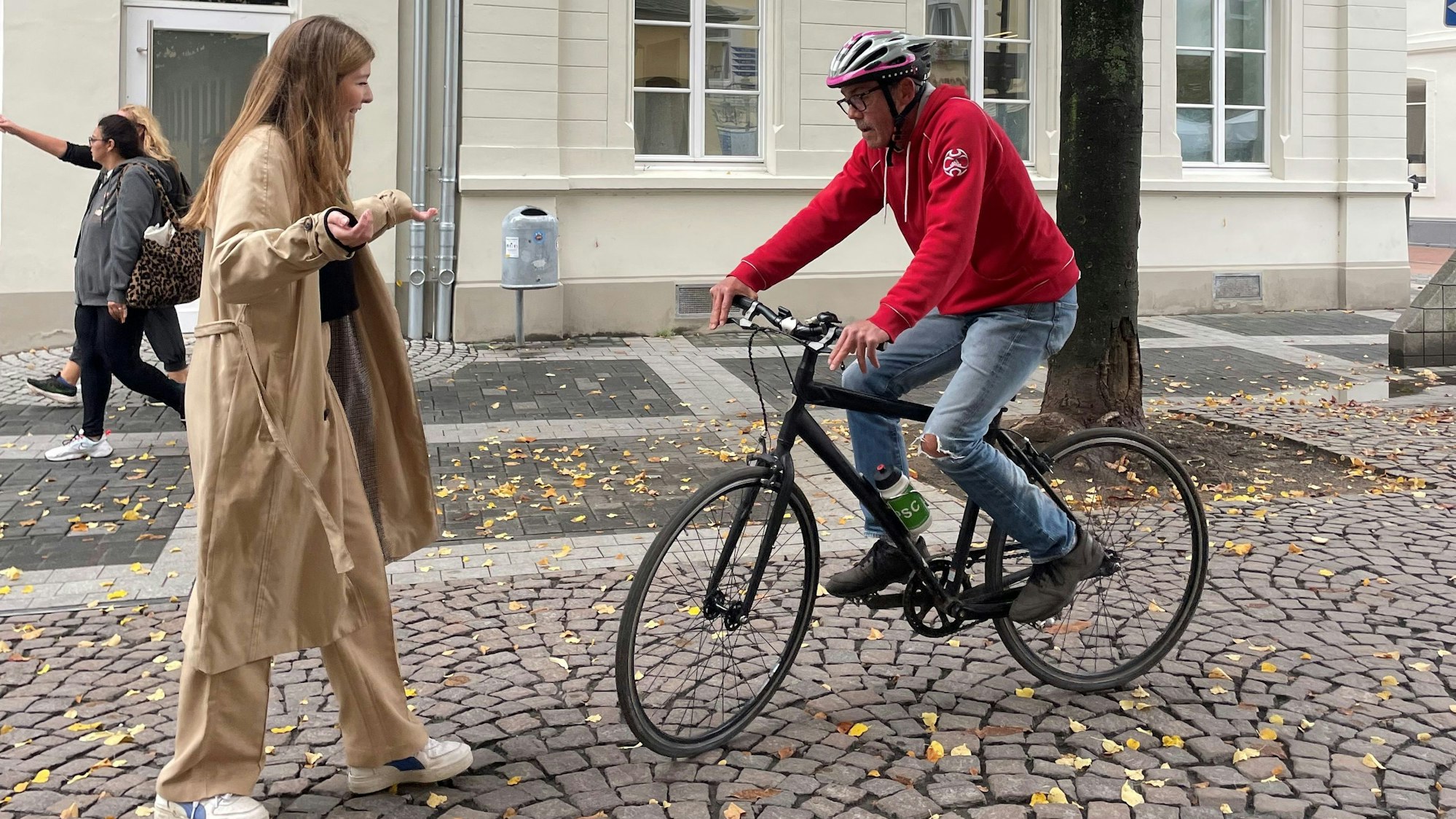 Zu sehen snd eineFußgängerin und ein Radfahrer.