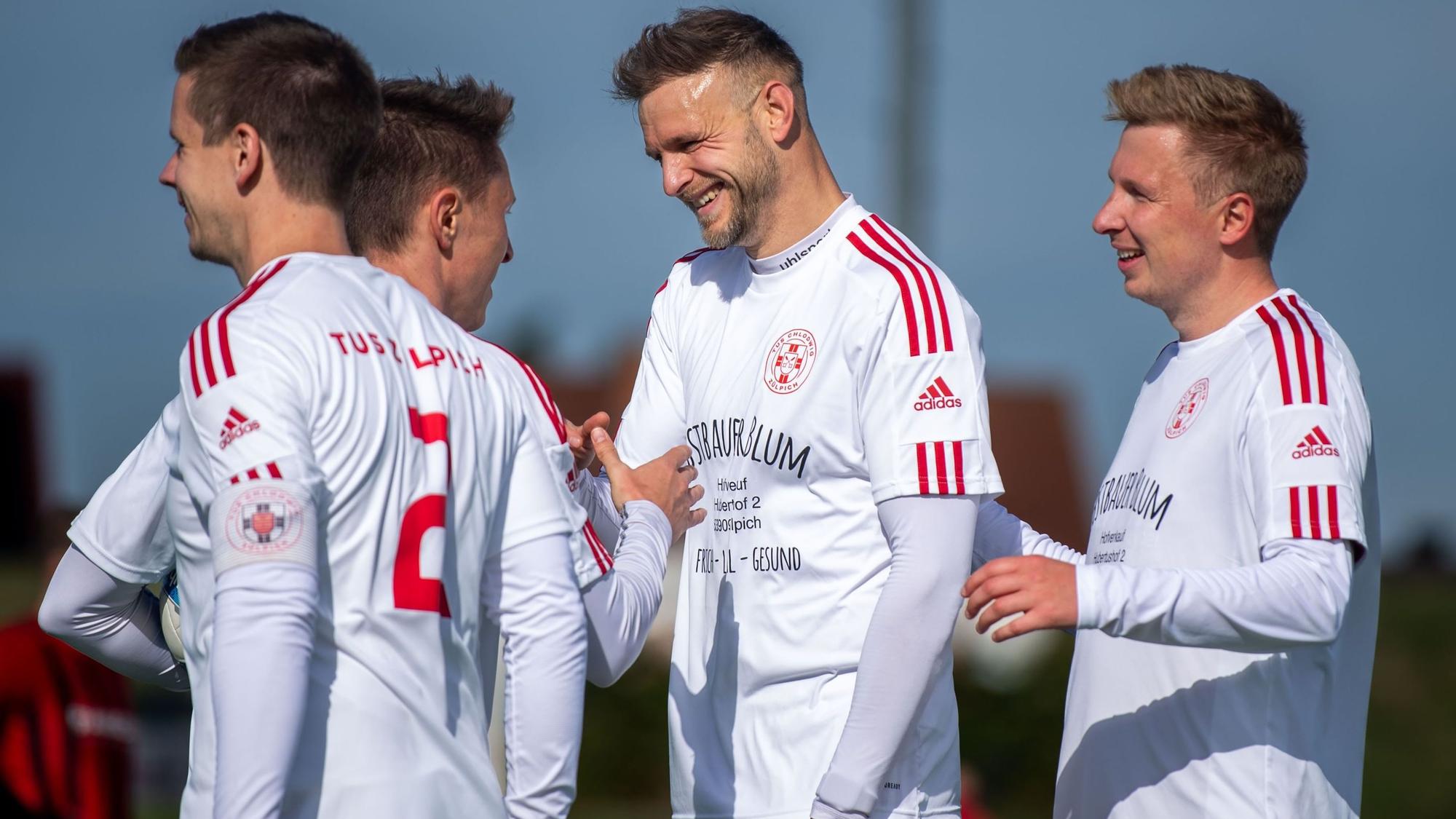 Das Bild zeigt vier Spieler des TuS Zülpich, die sich über einen Treffer freuen.