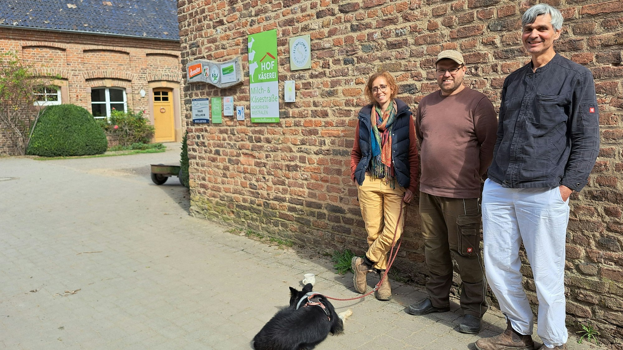 Ines von Hagenow, Christian Reiske und Olaf Seyd stehen vor einer Backsteinmauer des Hofes.