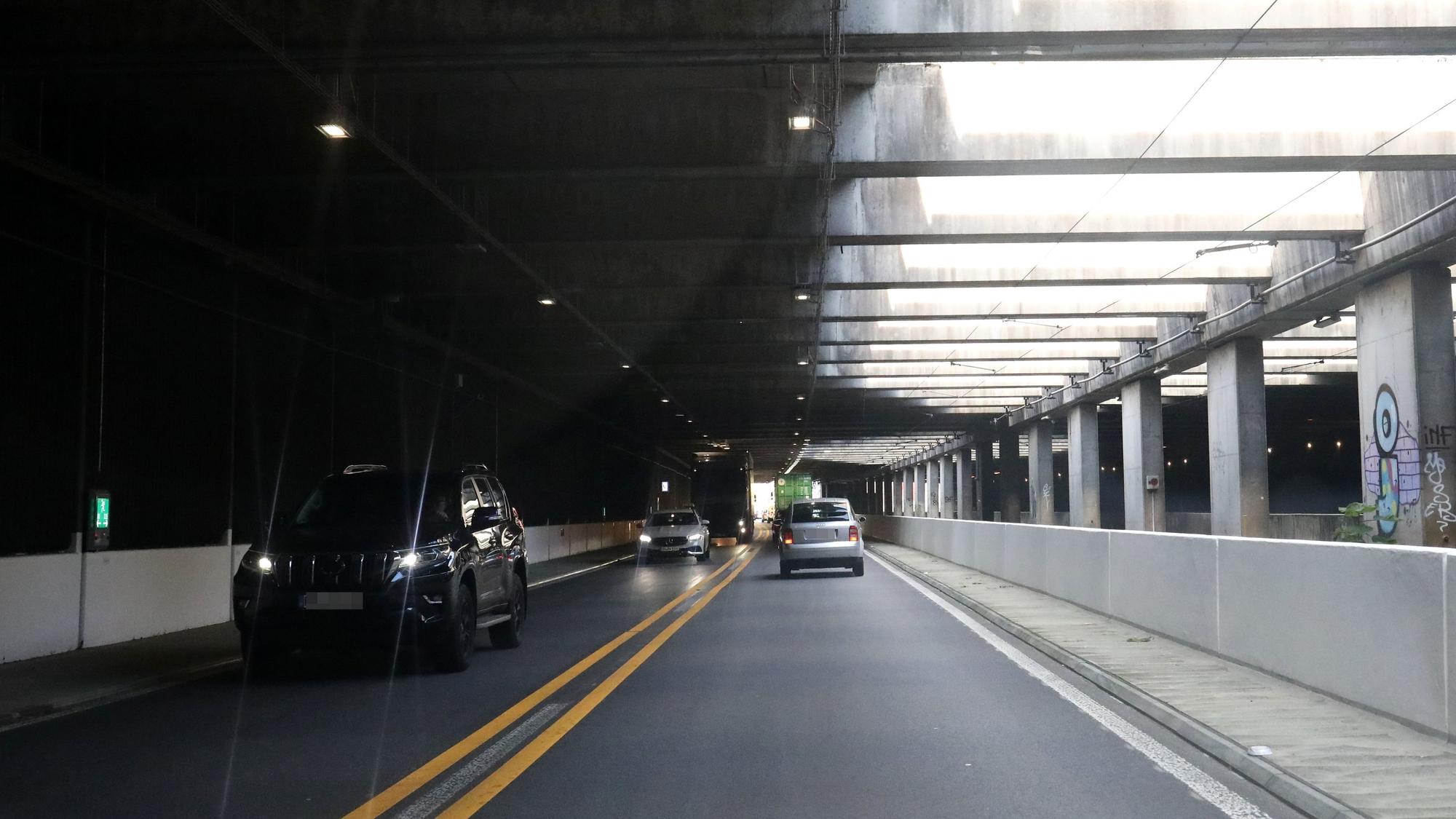 Fahrzeuge fahren durch einen Tunnel.