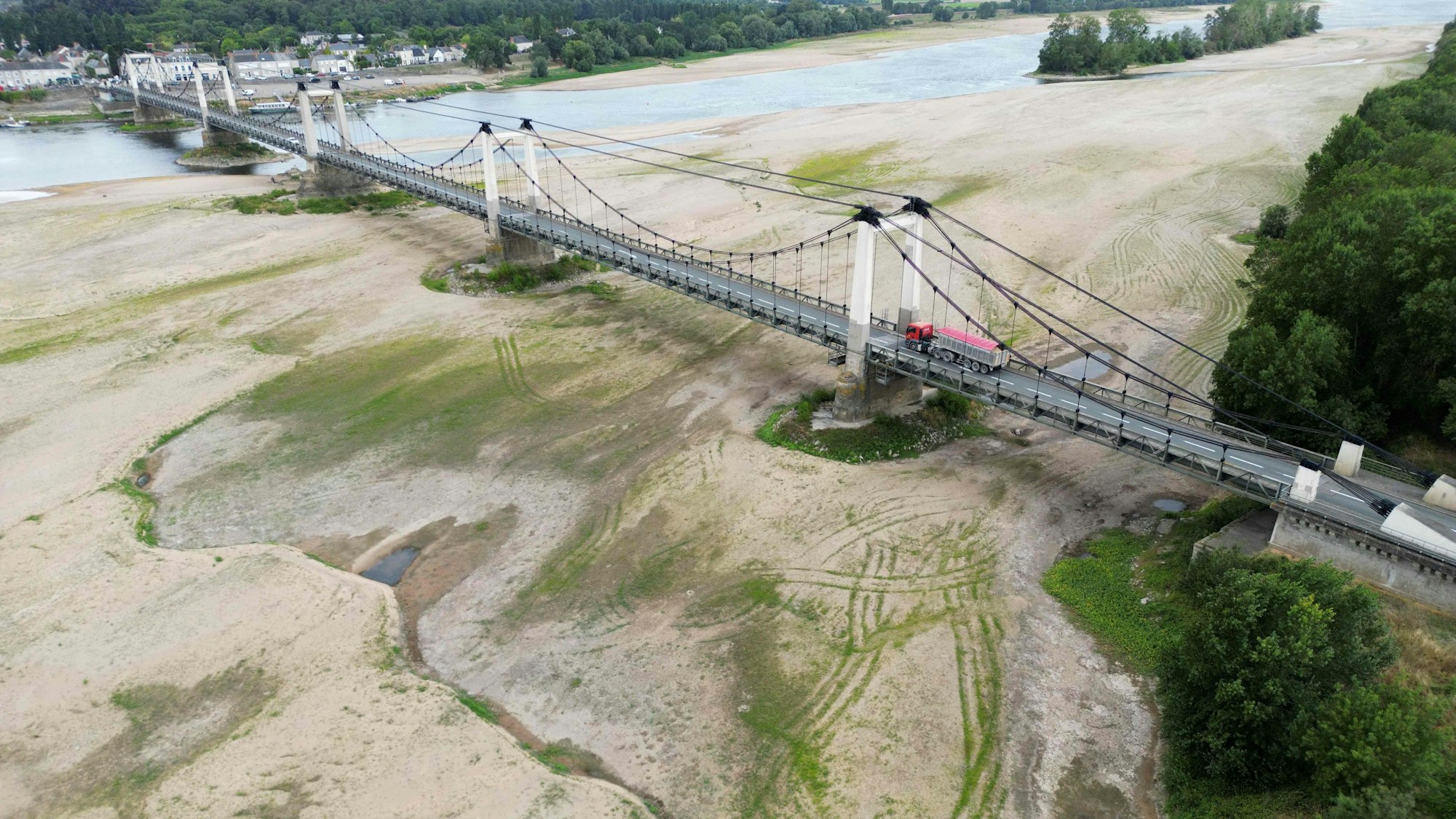 01.08.2023, Frankreich, Saint-Georges-Sur-Loire: Dieses Luftbild zeigt eine Brücke über das ausgetrocknete Flussbett der Loire in Saint-Georges-sur-Loire, Westfrankreich.