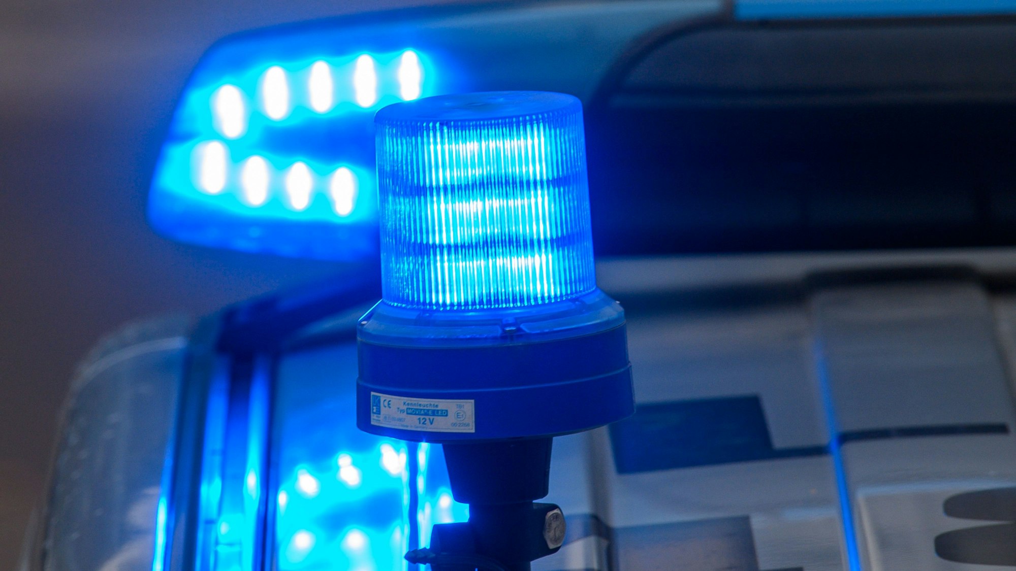 Das Blaulicht auf einem Polizeifahrzeug leuchtet.