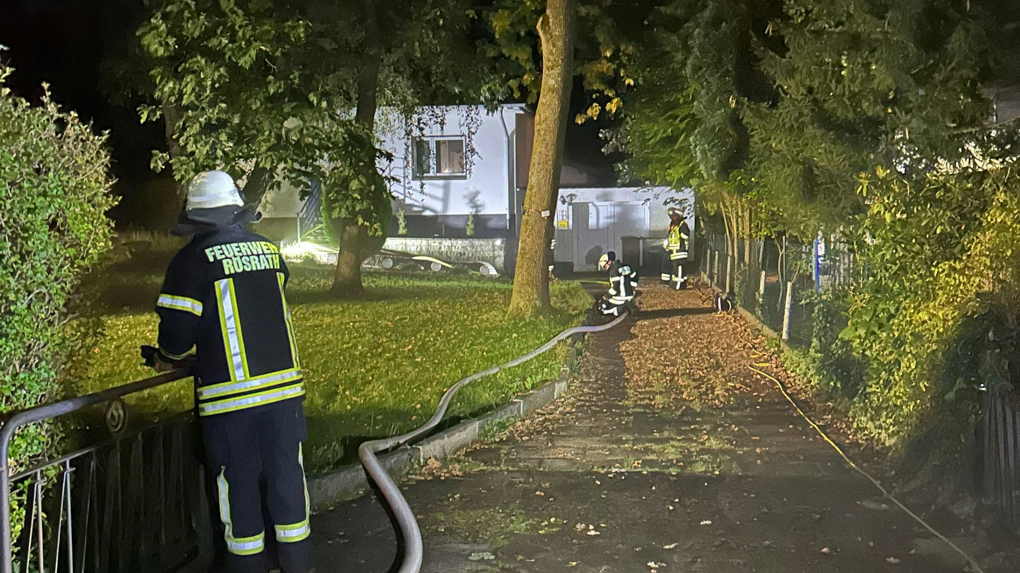 Ein Feuerwehrschlauch führt zu einem Haus, in dessen Keller es gebrannt hat.