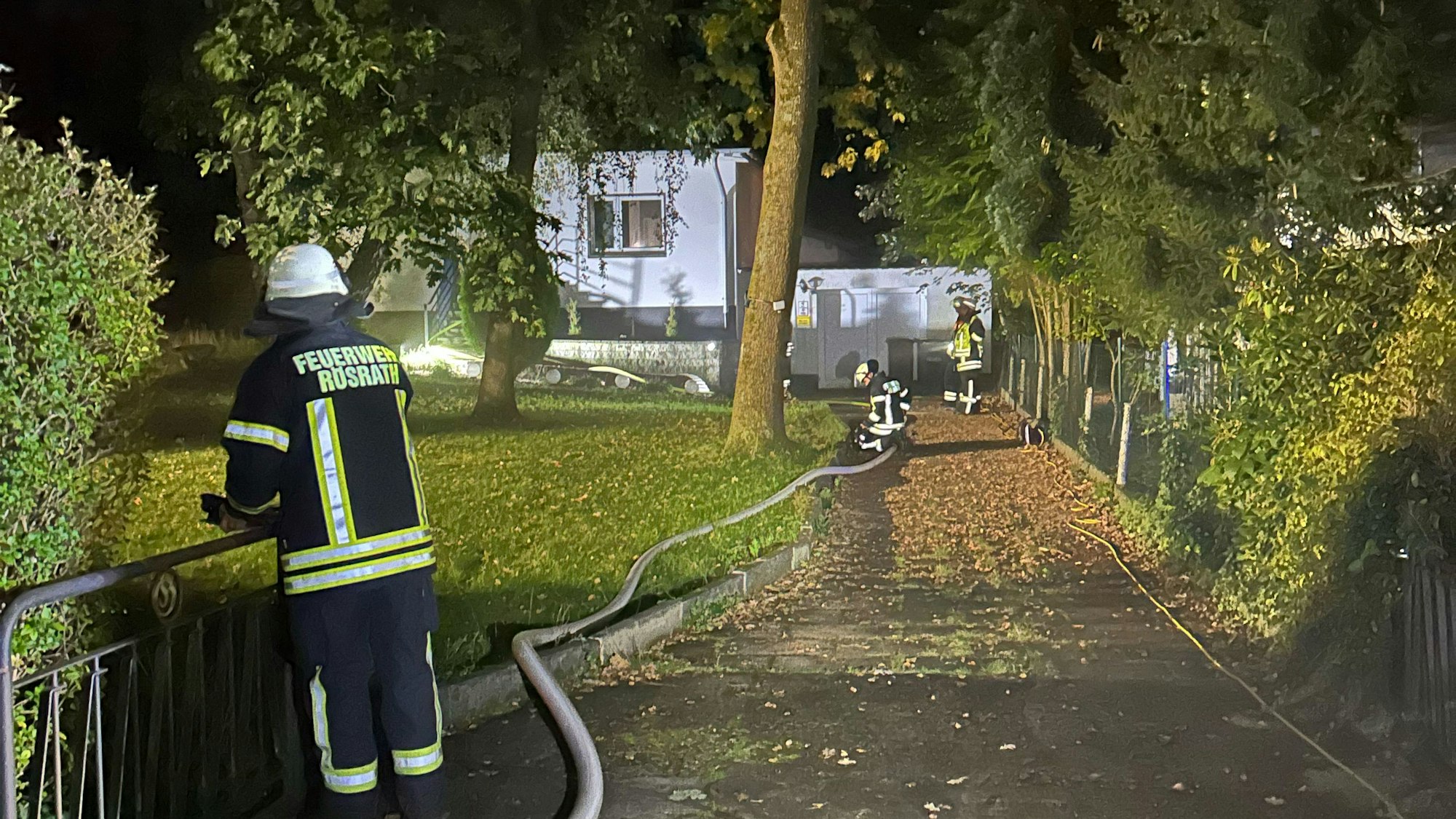 Ein Feuerwehrschlauch führt zu einem Haus, in dessen Keller es gebrannt hat.