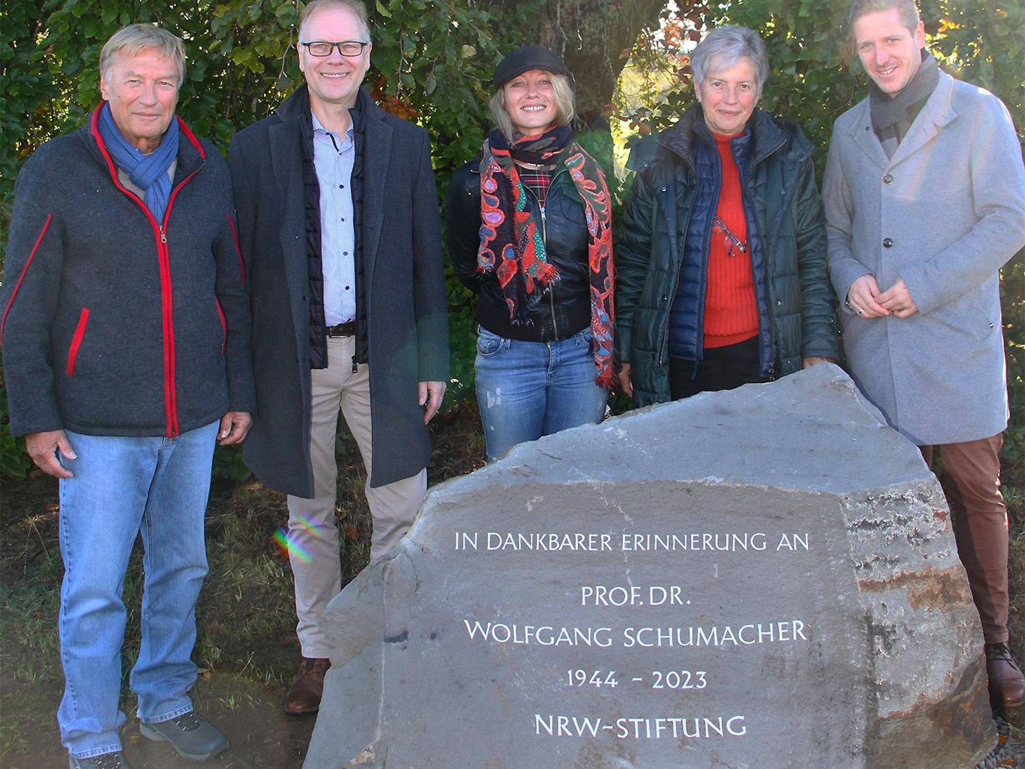 Harry Kurt Voigtsberger, Carsten Vorwig, Ulrike Gaubitz, Rita Schumacher und Landrat Markus Ramers stehen hinter dem Stein mit der Aufschrift „In dankbarer Erinnerung an Prof. Dr. Wolfgang Schumacher 1944-2023 NRW-Stiftung “.