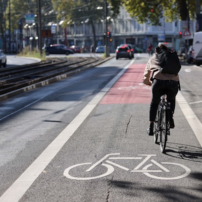 Ein Radfahrer fährt auf einer eigenen Fahrradspur auf der Straße.