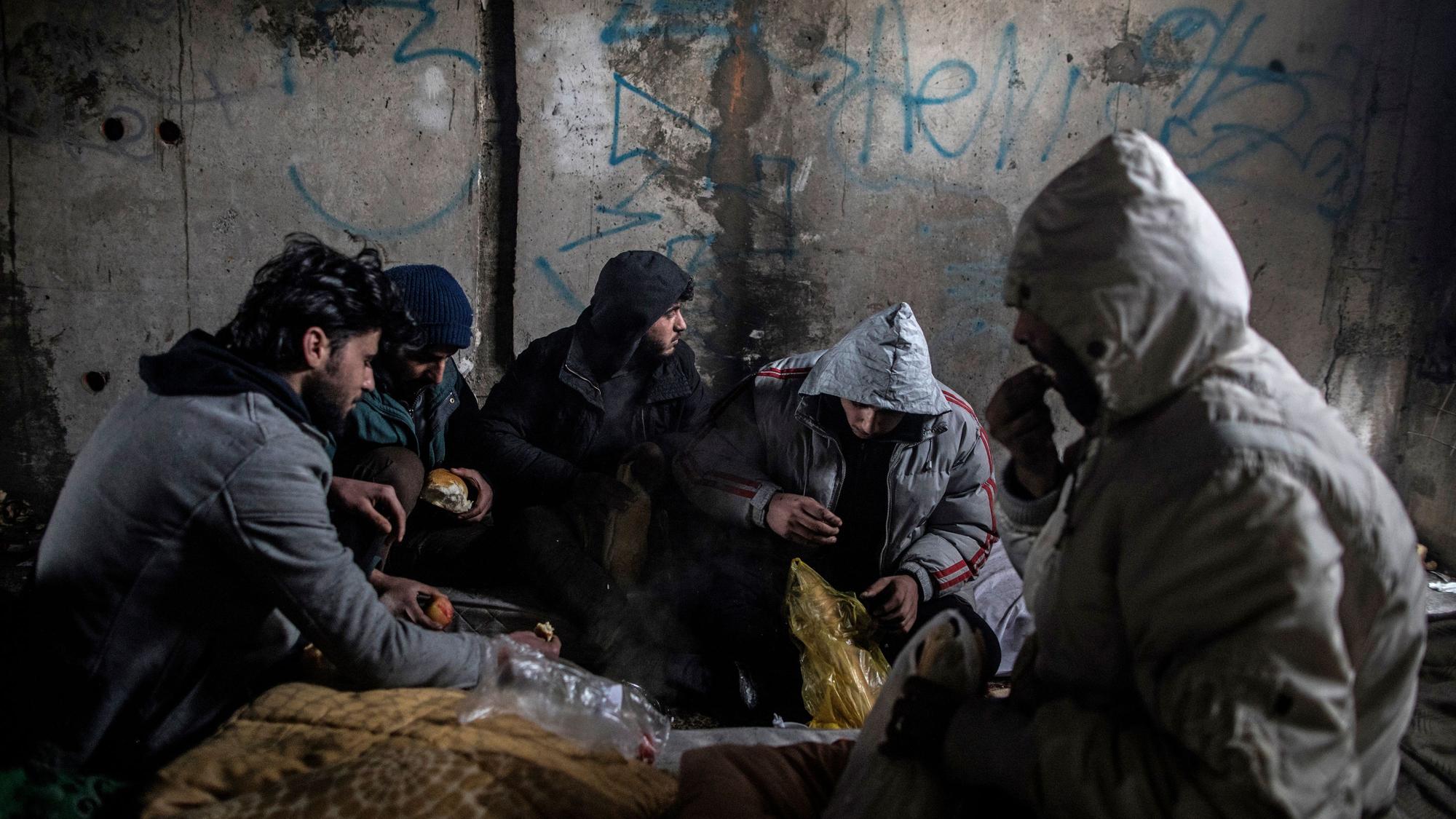 Eine Gruppe syrischer Migranten frühstückt in einem verlassenen Gebäude, in dem sie Unterschlupf gesucht hatten.
