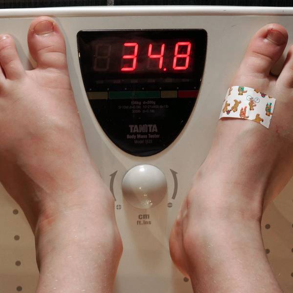 Ein siebenjähriges Schulkind steht auf einer Personenwaage. Die Waage zeigt ein Gewicht von 34,8 Kilogramm an, dies ist ein deutliches Übergewicht.