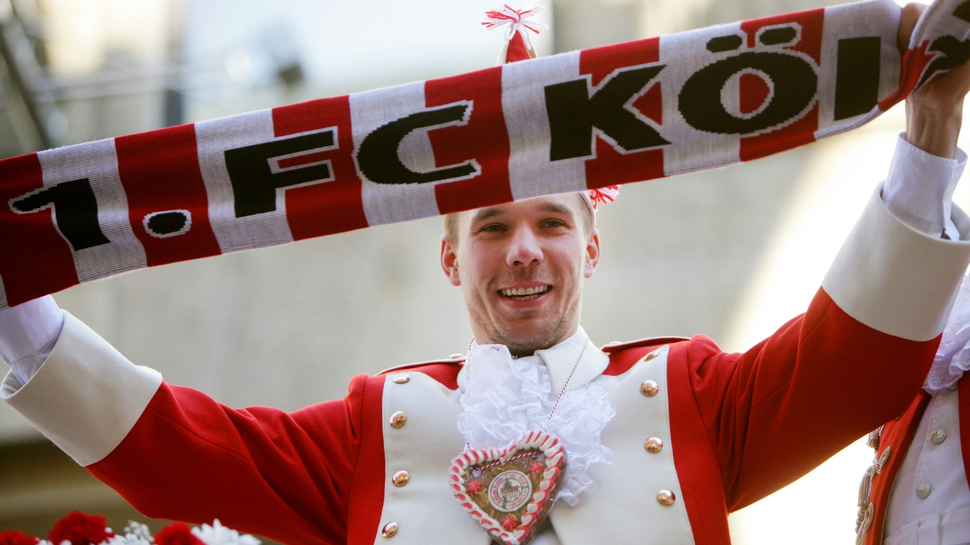 Fußball-Nationalspieler Lukas Podolski fährt beim Rosenmontagsumzug in Köln auf dem Wagen der Roten Funken mit.