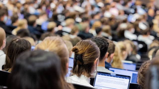 Münster: Studentinnen und Studenten sitzen während einer Vorlesung in einem Hörsaal.