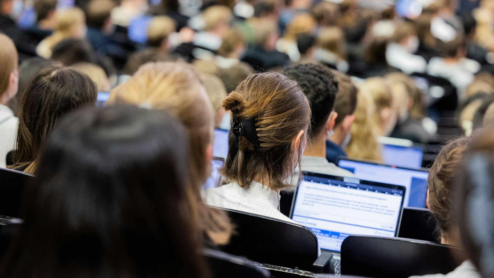 Münster: Studentinnen und Studenten sitzen während einer Vorlesung in einem Hörsaal.