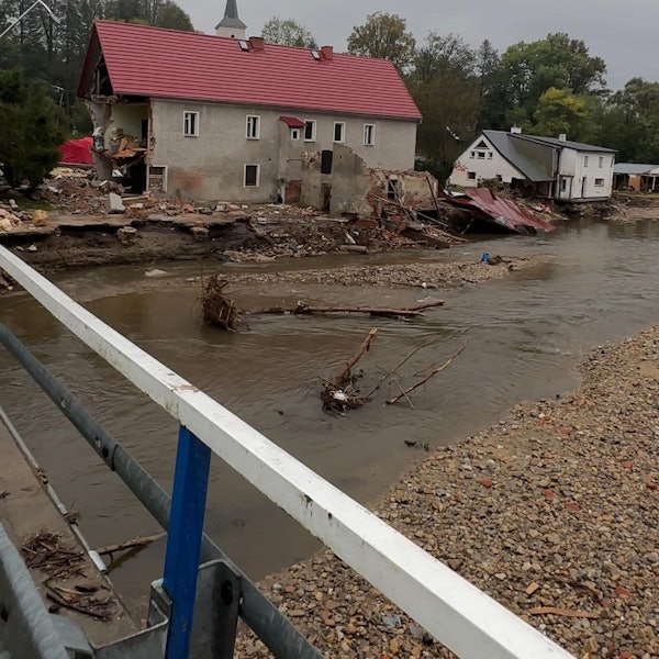 Das Bild zeigt zwei stark in Mitleidenschaft gezogene Häuser an einem Fluss in Polen.