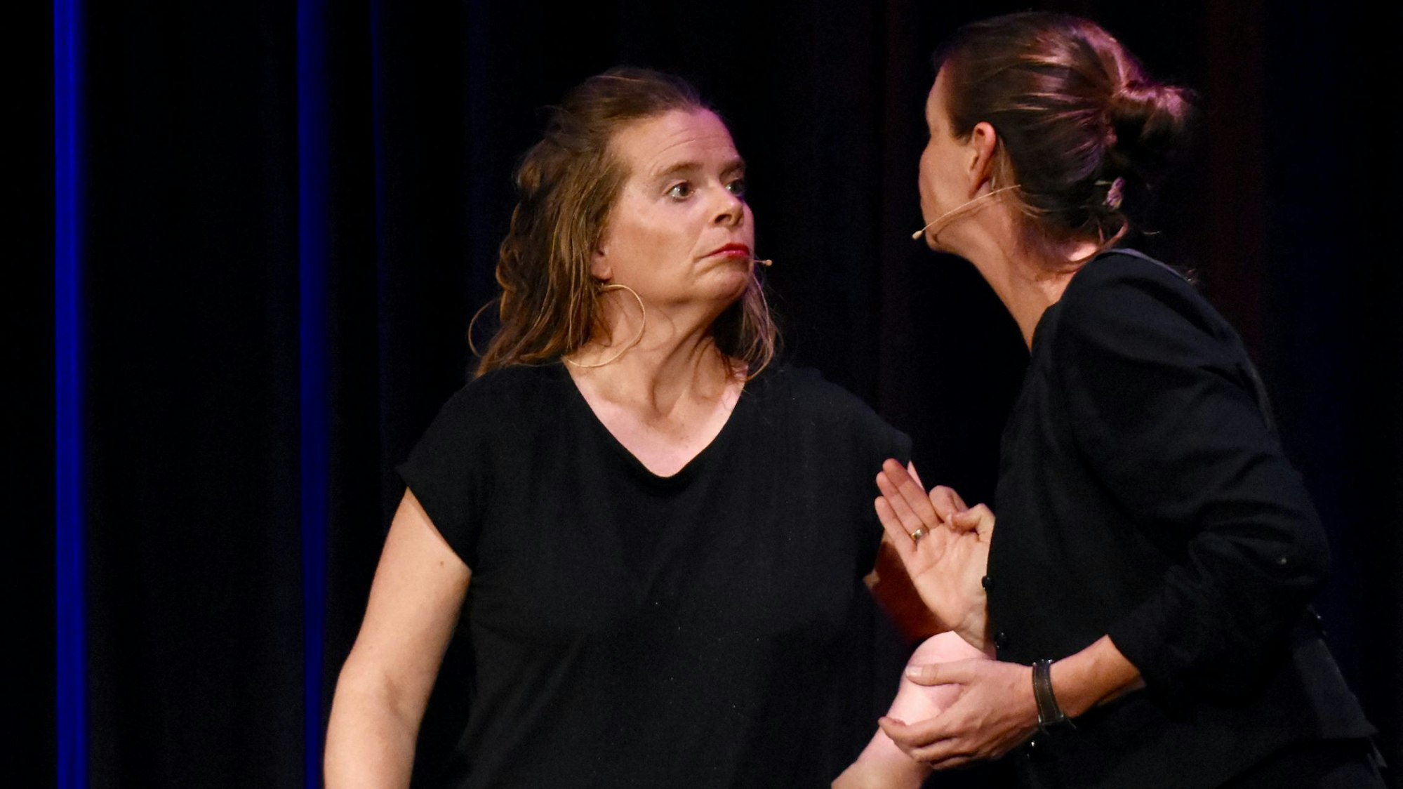 Zwei Frauen im Dialog auf einer Bühne.