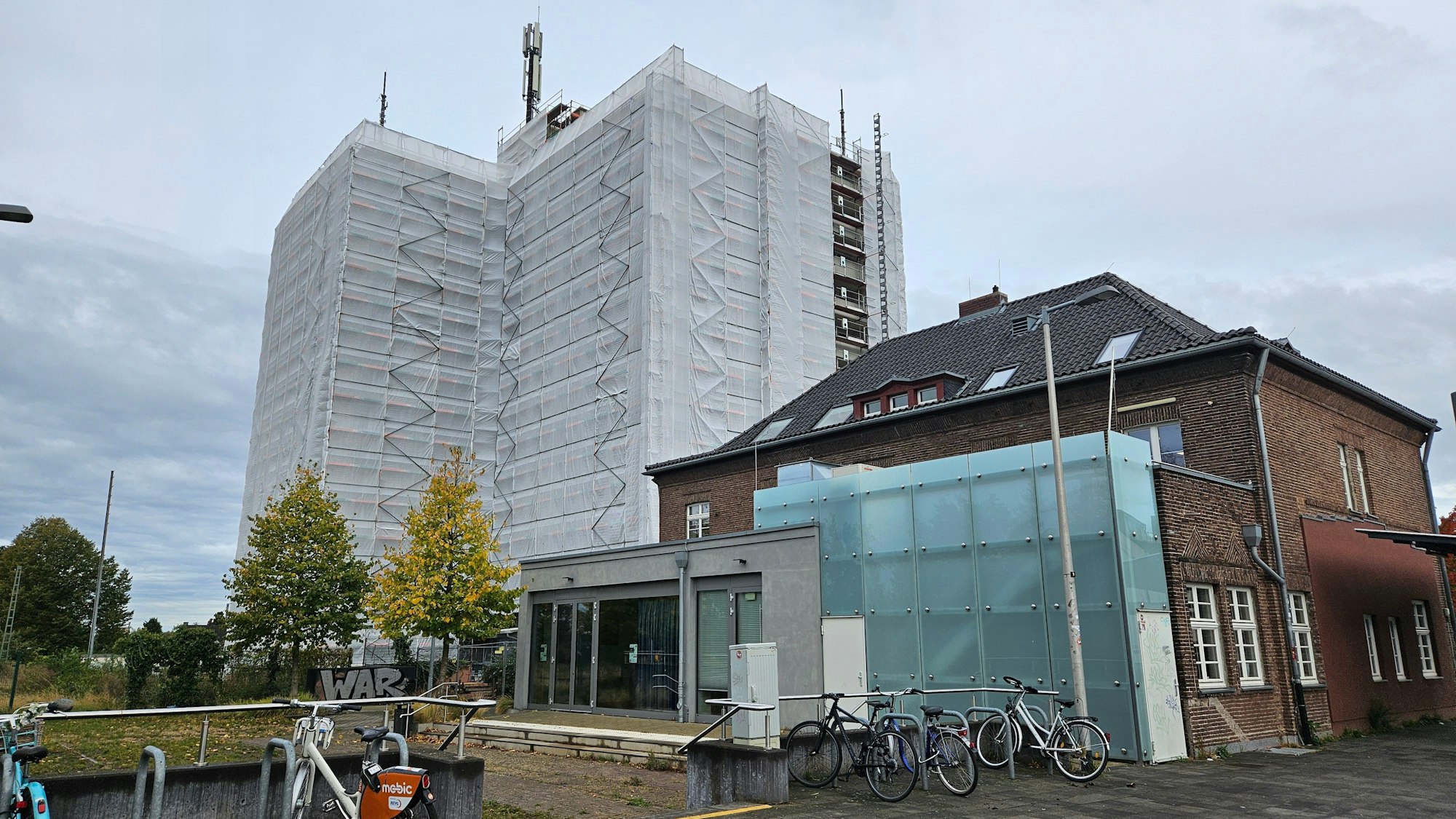 Ein mehrstöckiges Gebäude ist eingerüstet und mit Planen verhüllt.