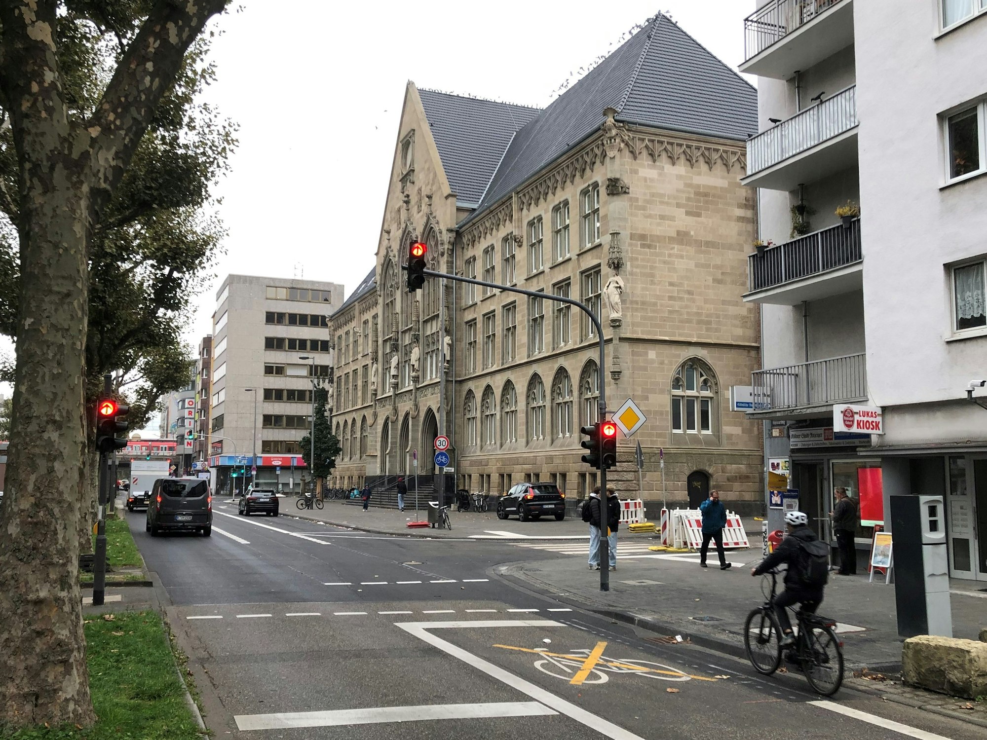 Ein Radfahrer wartet vor einer roten Ampel am Kölner Hansagymnasium.
