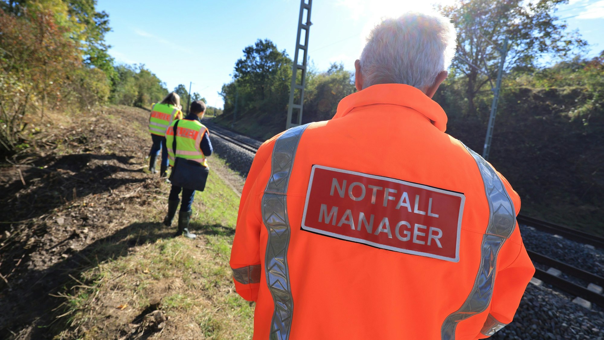 Ein Notfallmanager der Deutschen Bahn und Beamte der Kriminalpolizei untersuchen eine Unfallstelle.