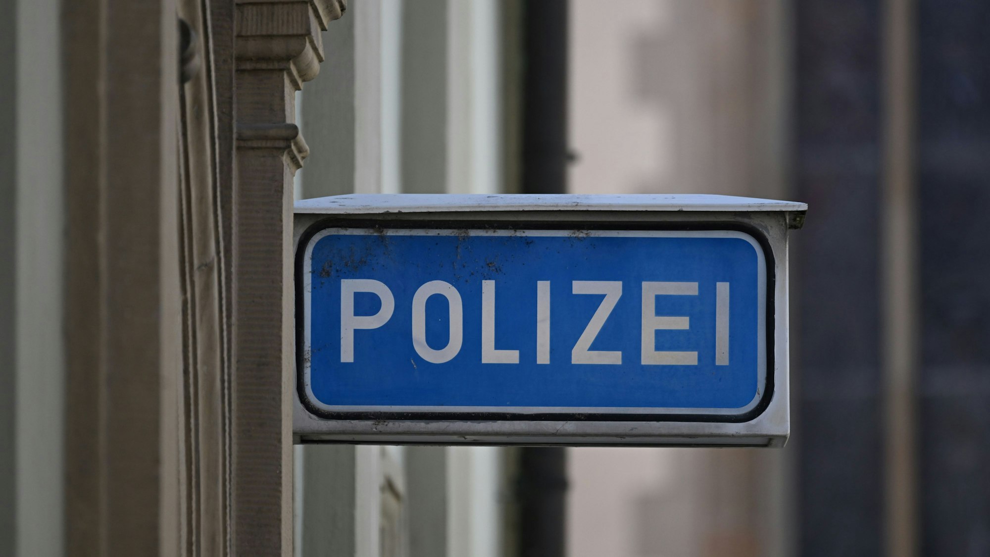 Ein Schild mit der Aufschrift Polizei vor einer Polizeiwache.