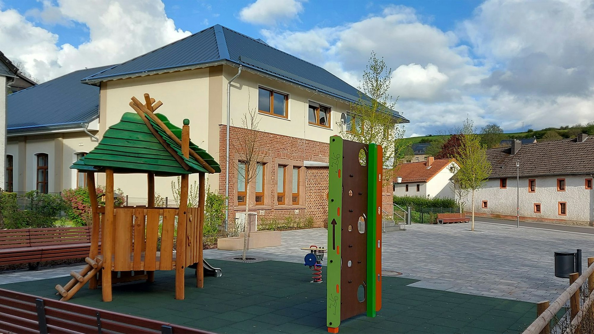 Spielgeräte und Sitzbänke stehen auf dem Dorfplatz von Dahlem.