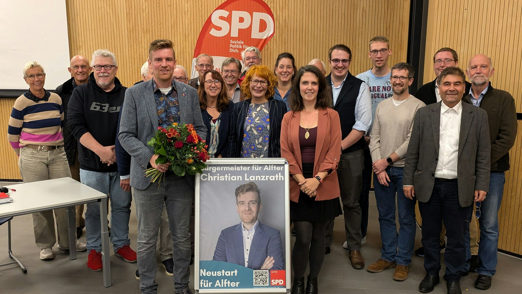 Mit Blumen, Plakat und Rückendeckung der Genossen: Christian Lanzrath.