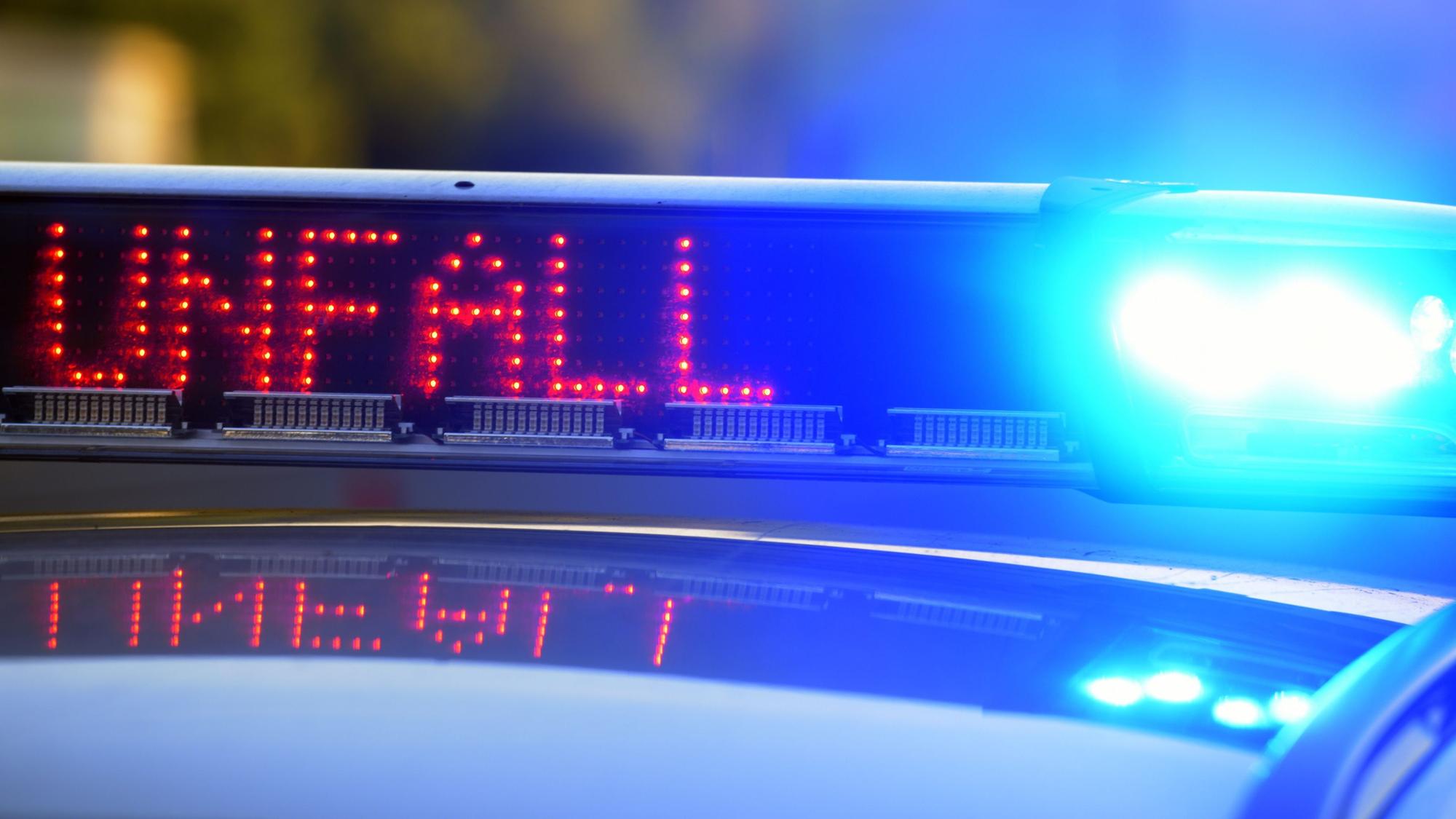 Auf einem Polizeifahrzeug warnt eine Leuchtschrift vor einer Unfallstelle.