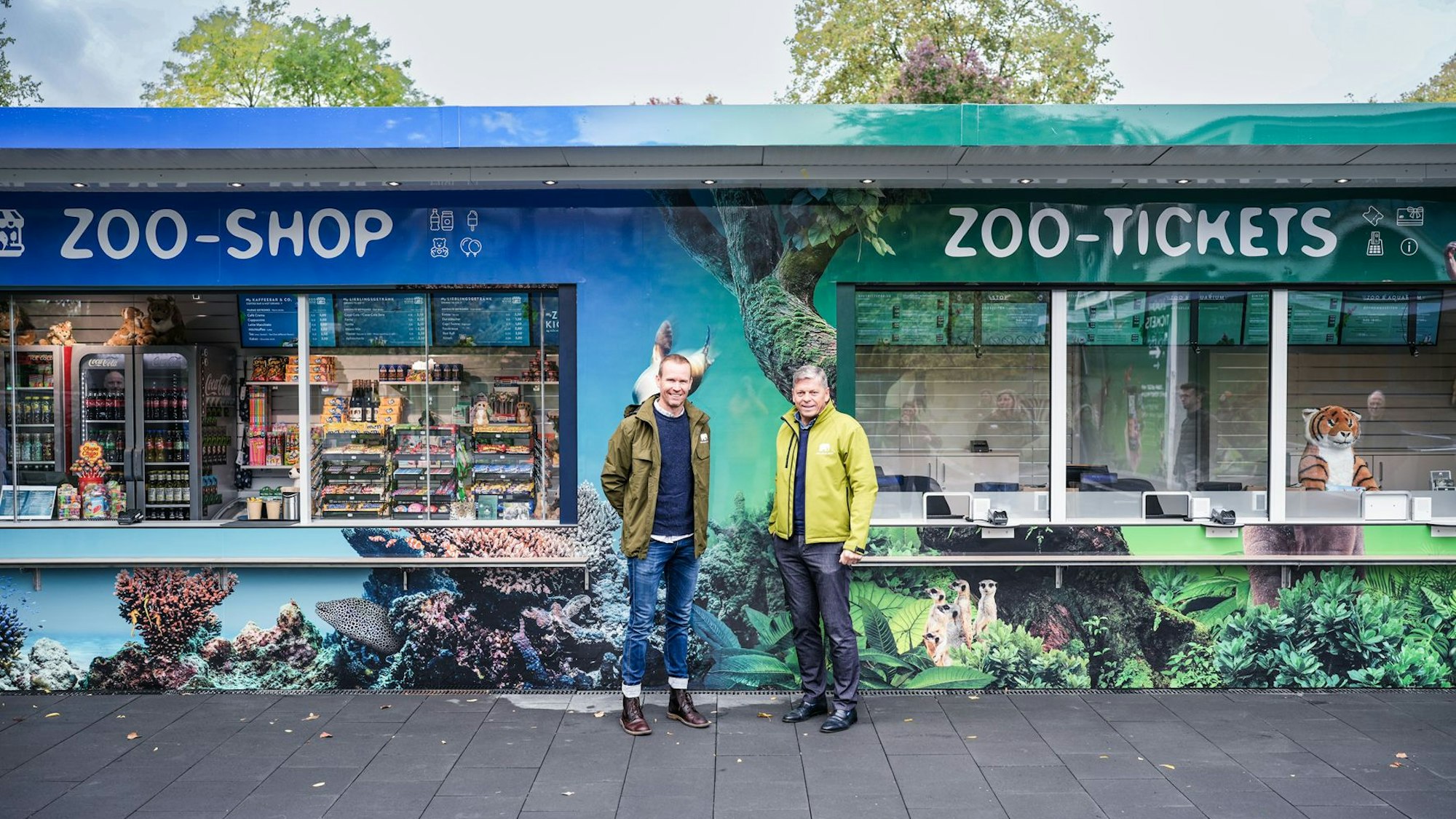 Freuen sich über den neuen und aufwendig gestalteten Kiosk: Thorsten Hoenen, Geschäftsführer Kölner ZooShop GmbH und Zoo-Vorstand Christopher Landsberg (v.l.).