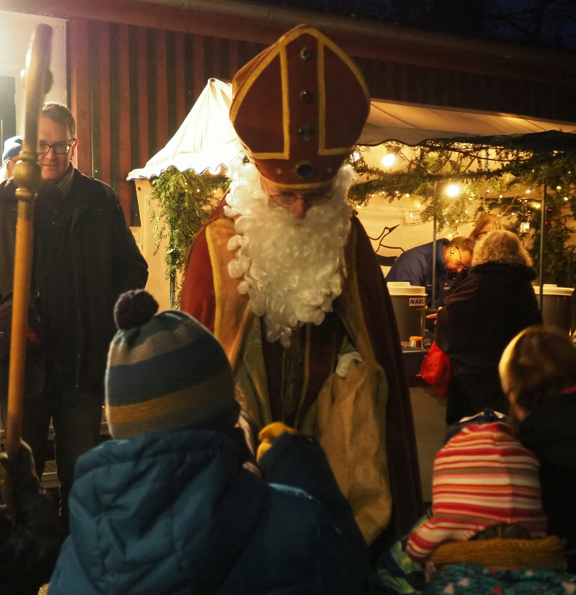 Das Foto zeigt einen Nikolaus, der einem Kind die Hand schüttelt.