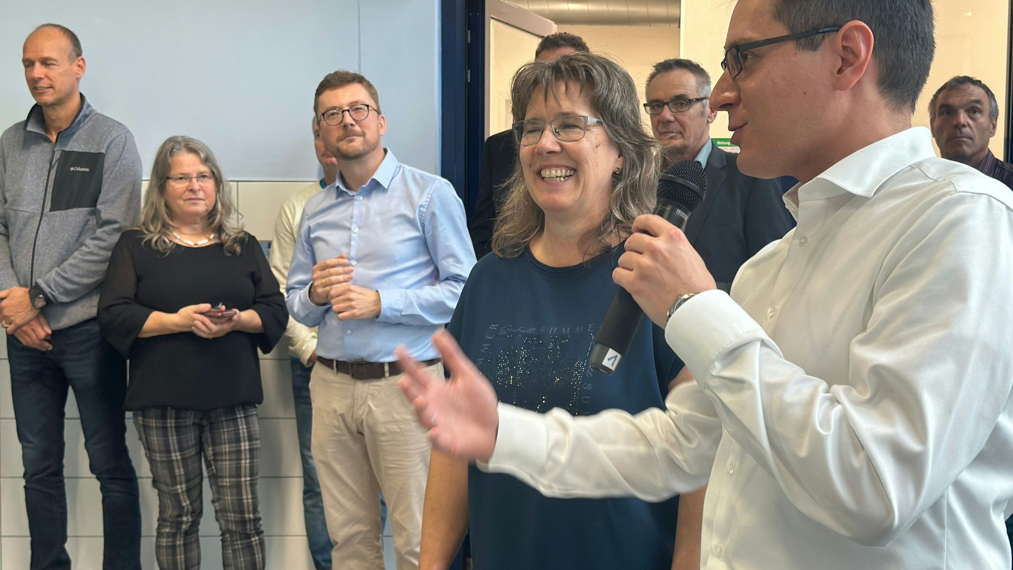 Bürgermeister Max Leitterstorf hält ein Mikrofon in der Hand und lobt in seiner Rede die Arbeit der städtische Projektleiterin Wenke Schallenberg-Hüls, die neben ihm steht.