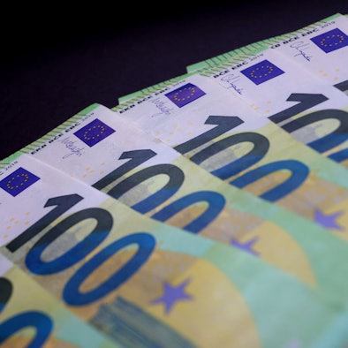 100-Euro Banknoten liegen auf einem Tisch.