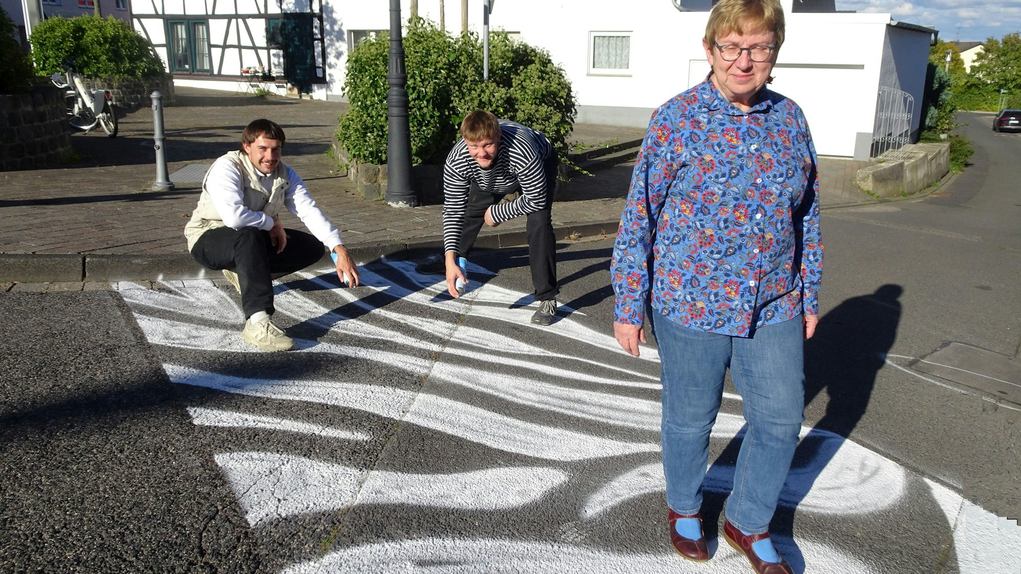 Ortsvorsteherin Monika Kerstholt geht über eine innovative Straßenquerung.