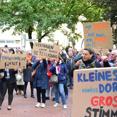 Das Bild zeigt mehrere Demonstranten vor dem Rathaus in Frechen