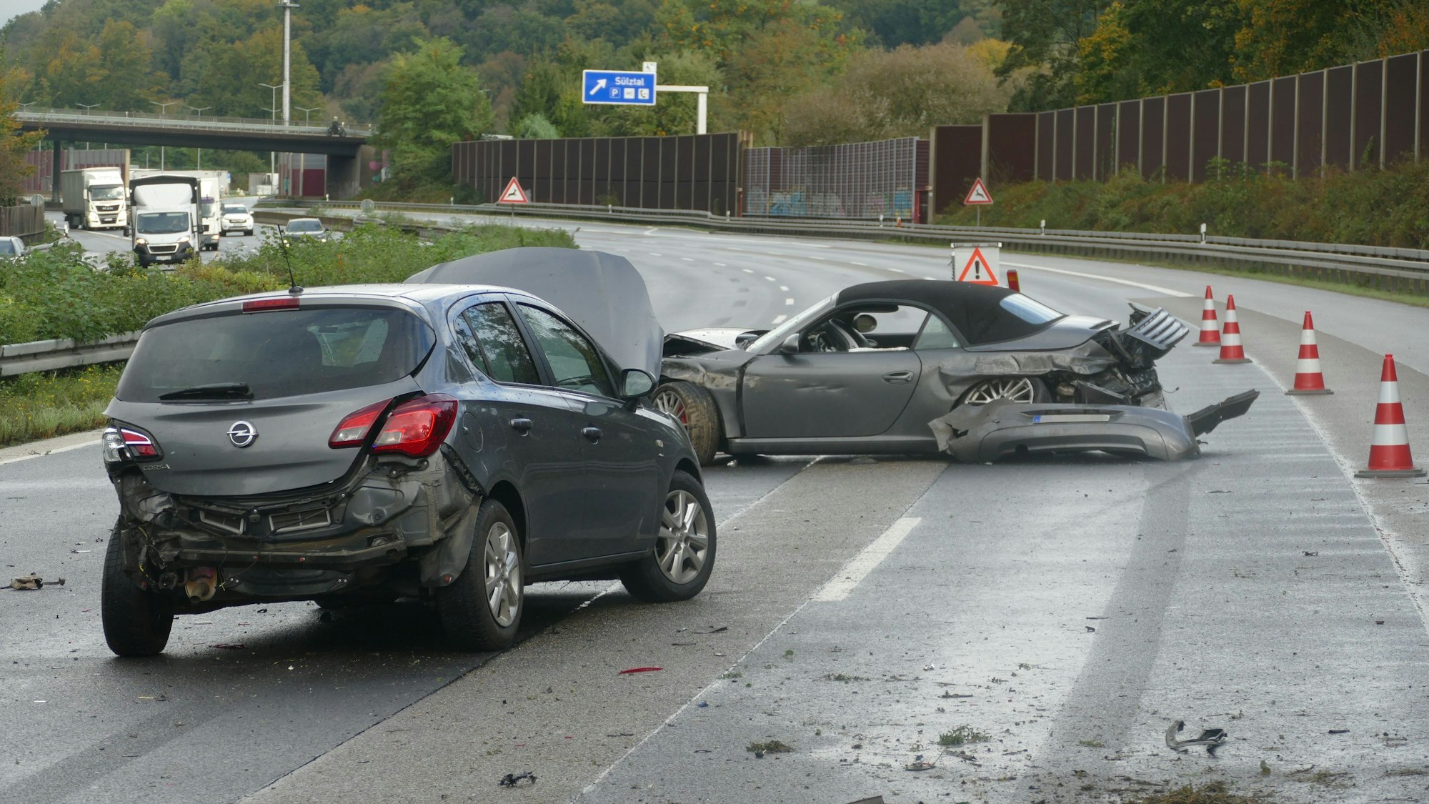 Zwei kaputte Autos stehen auf der Autobahn.