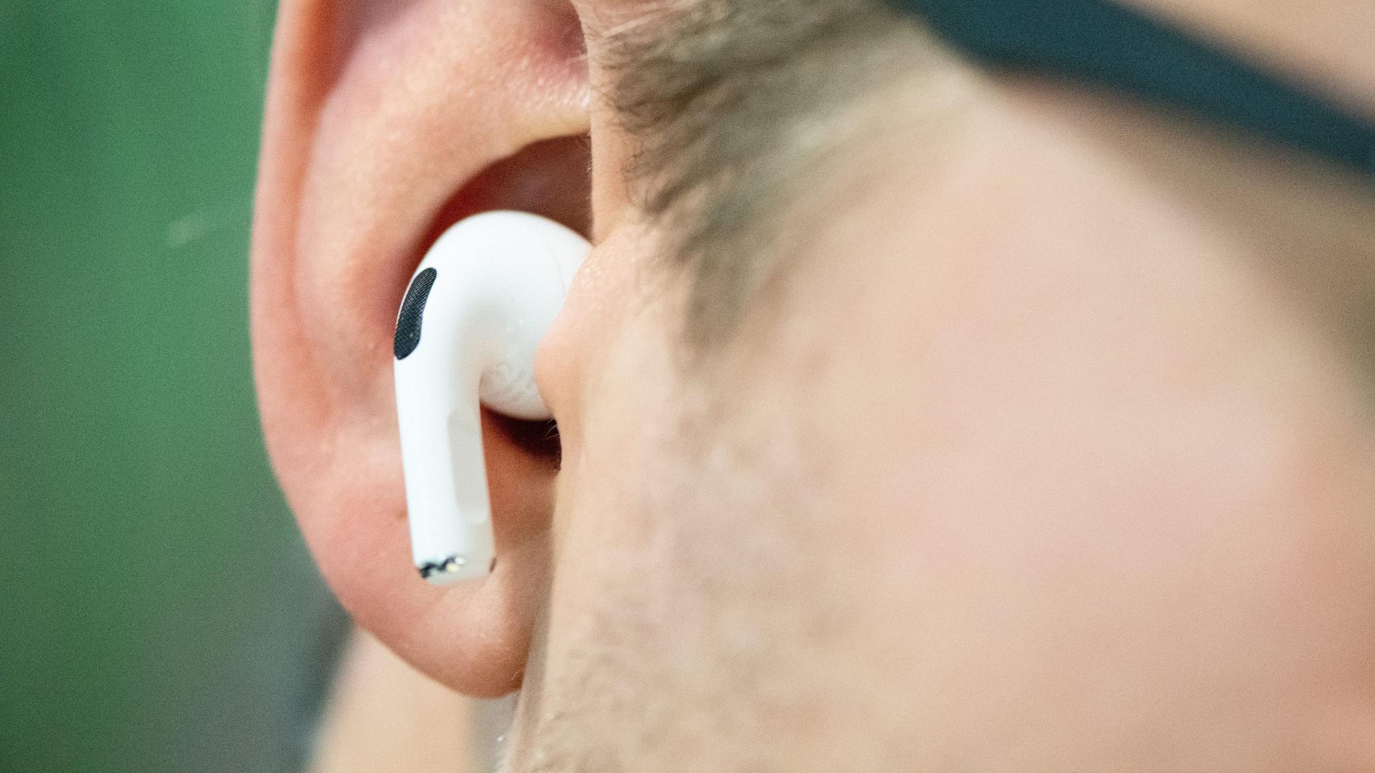 Eine Person trägt einen Bluetooth-Kopfhörer von Apple.