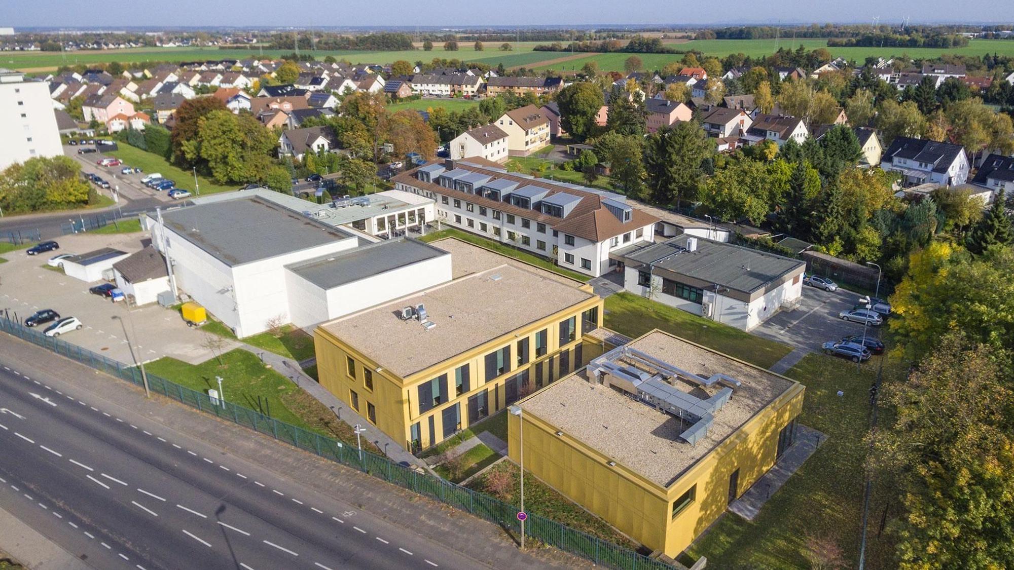 Ein Luftbild des Instituts, das aus mehreren Komplexen besteht; im Hintergrund Wohnhäuser.