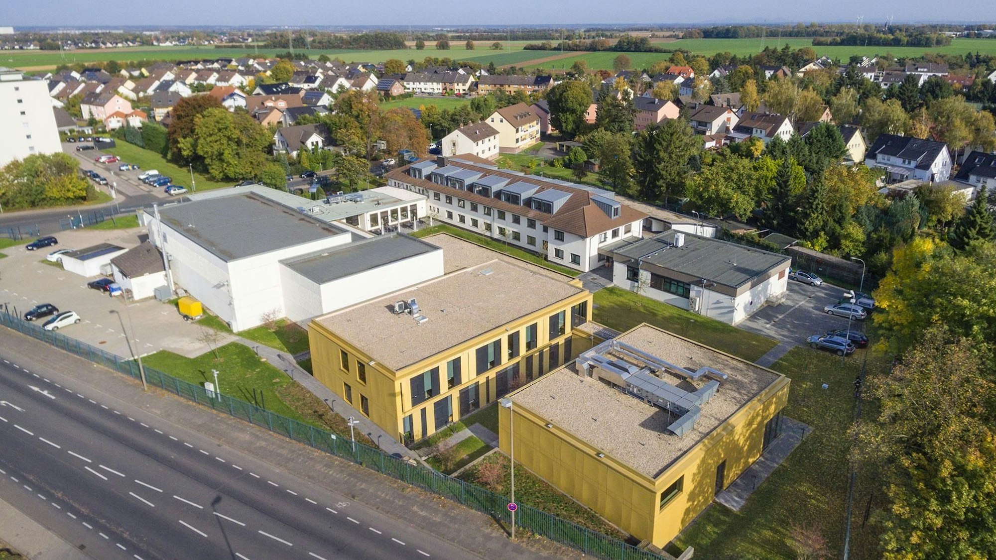 Ein Luftbild des Instituts, das aus mehreren Komplexen besteht; im Hintergrund Wohnhäuser.
