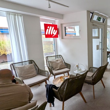 Blick in den Gastraum der Café-Bar Lou in Gemünd, wo ein paar Gäste an Tischen sitzen.