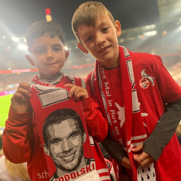 Zwei kleine Fußballfans stehen im Stadion des 1. FC Köln.