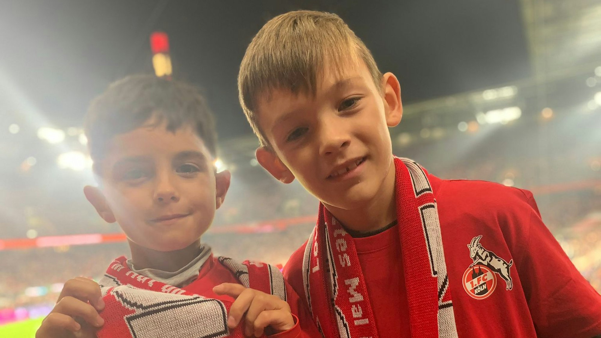 Zwei kleine Fußballfans stehen im Stadion des 1. FC Köln.