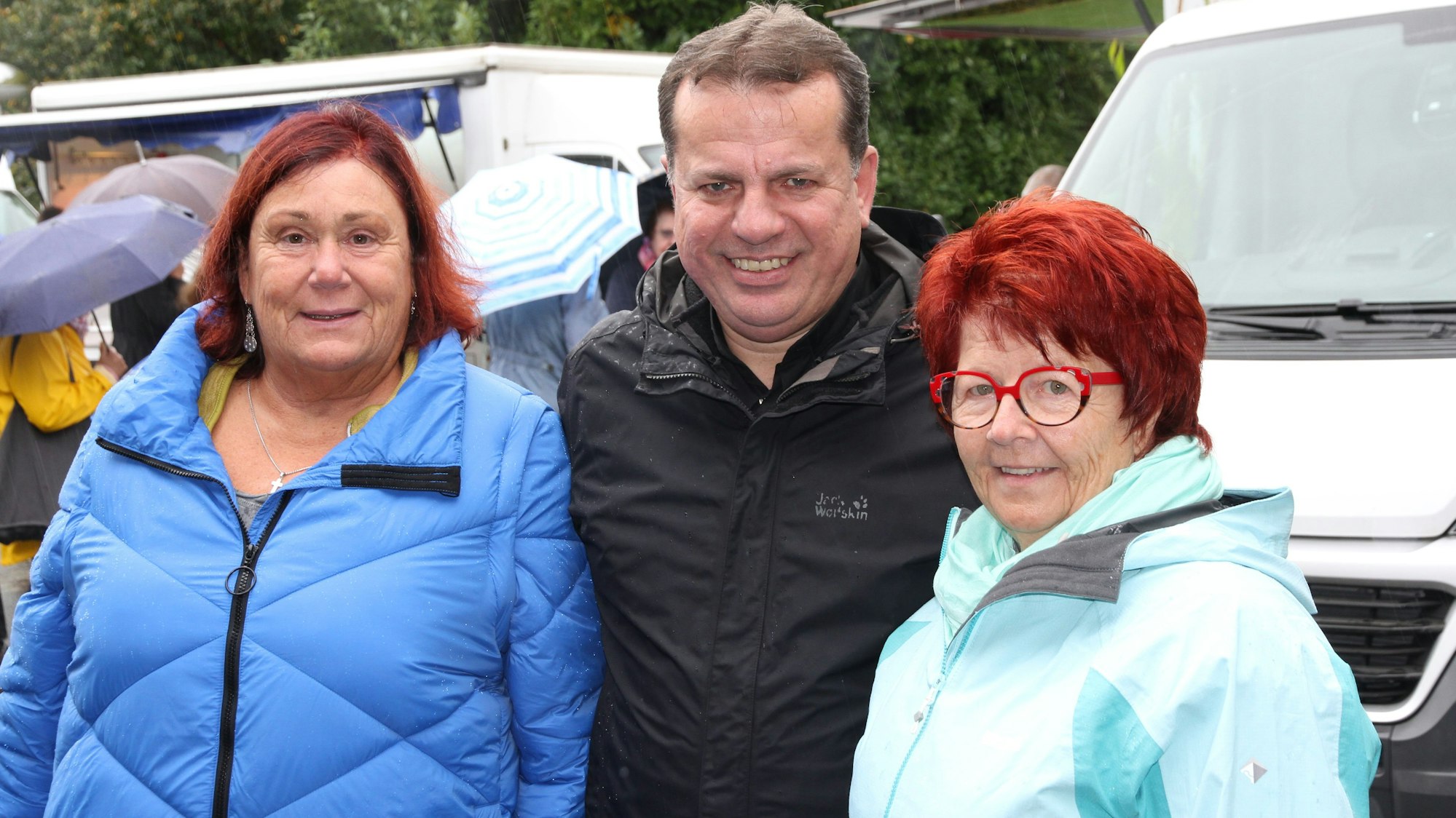 Zwei Männer und eine Frau in Wetterjacken