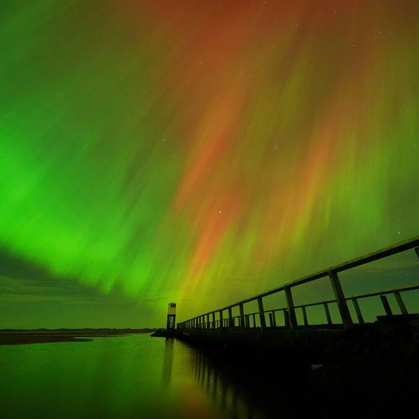 Nordlichter am Himmel über der Schutzhütte auf dem Damm, der zur Holy Island in Northumberland an der Nordostküste Englands führt, zu sehen.
