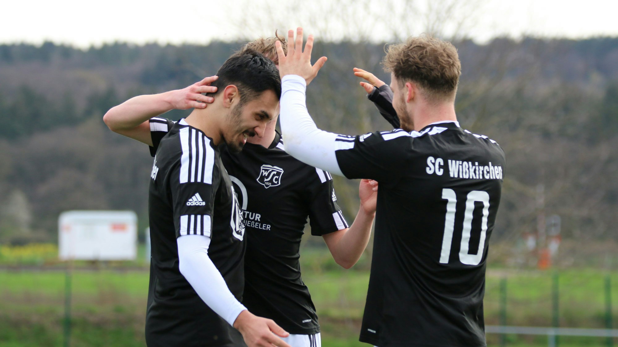 Das Bild zeigt drei Spieler des SC Wißkirchen, die ein Tor bejubeln.