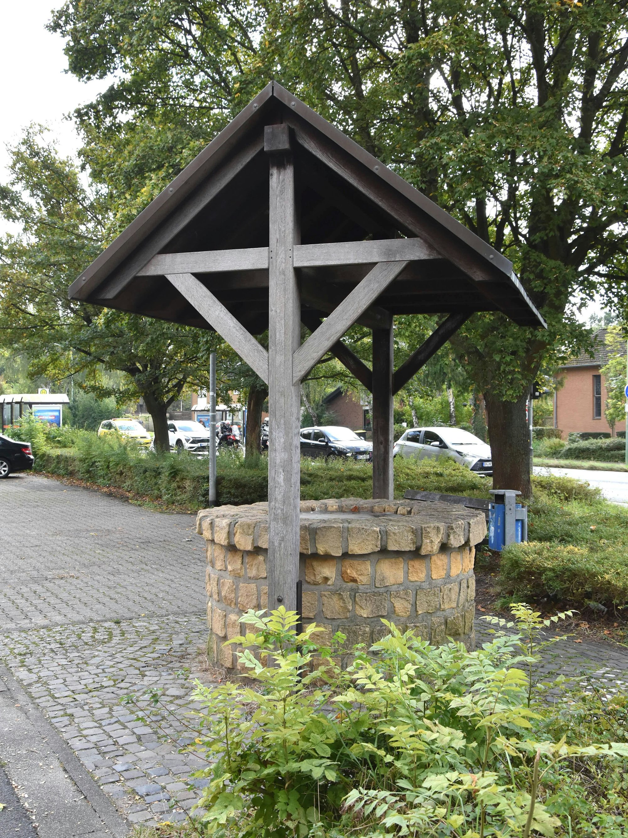 Das Bild zeigt einen Brunnen an einem Parkplatz.