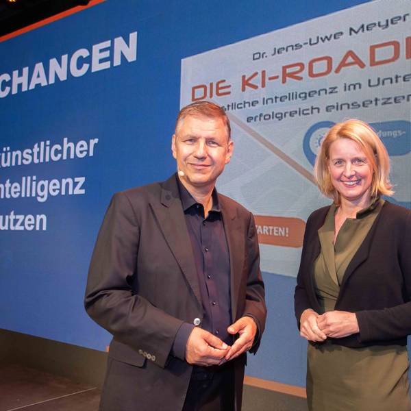 Eine Frau und ein Mann stehen vor einer Präsentationswand