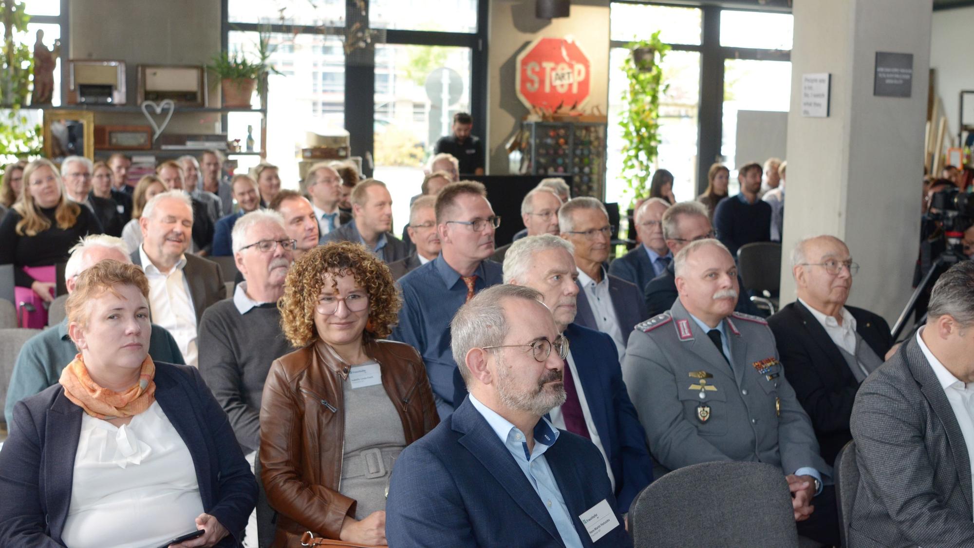 Festgäste sitzen in mehreren Reihen hintereinander.