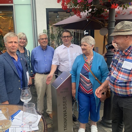 Eine Gruppe von Menschen an einem Trinkwasserspender.