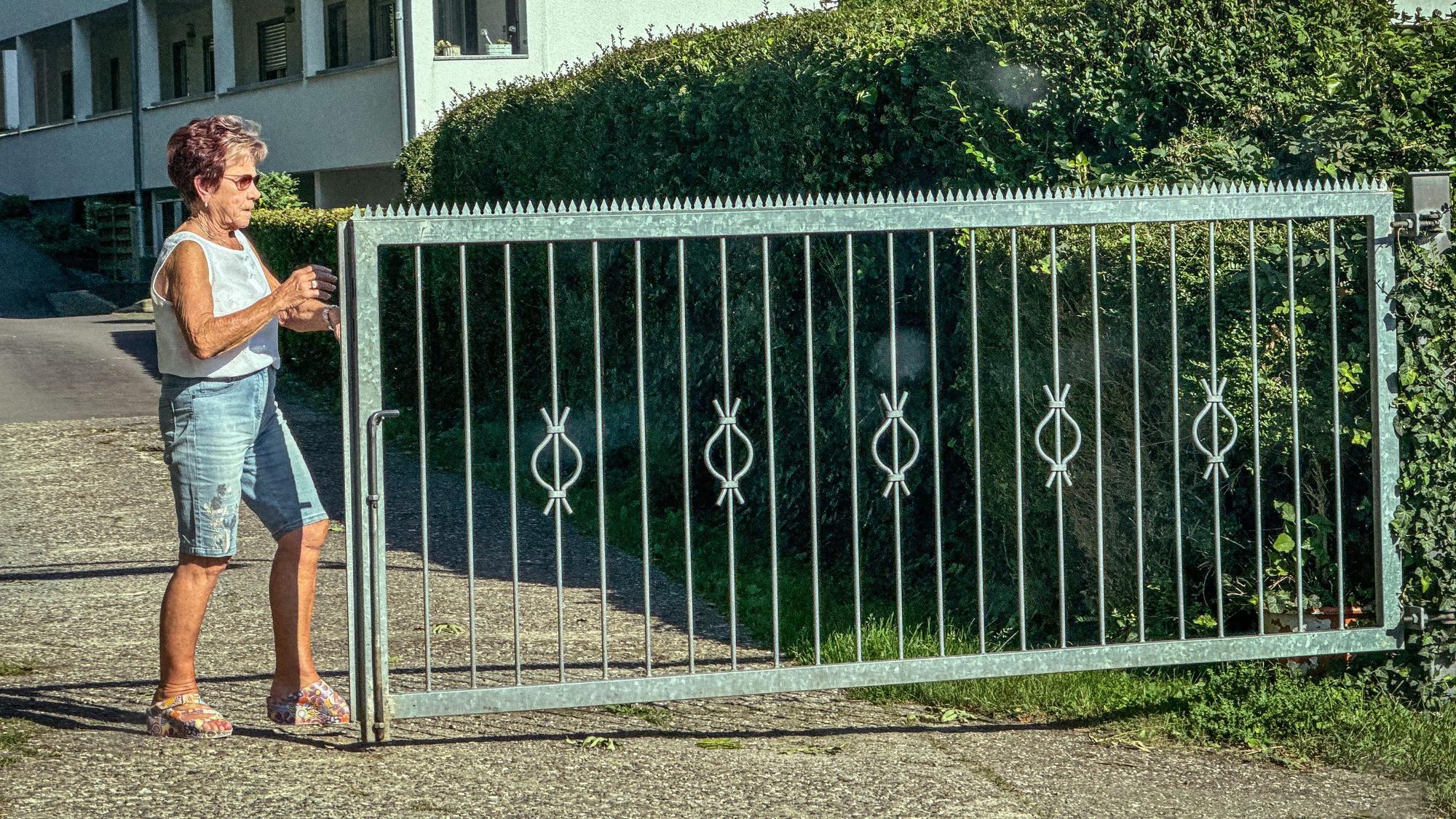Trudi Decker schiebt ein Tor zu, damit niemand auf den Campingplatz kommt.