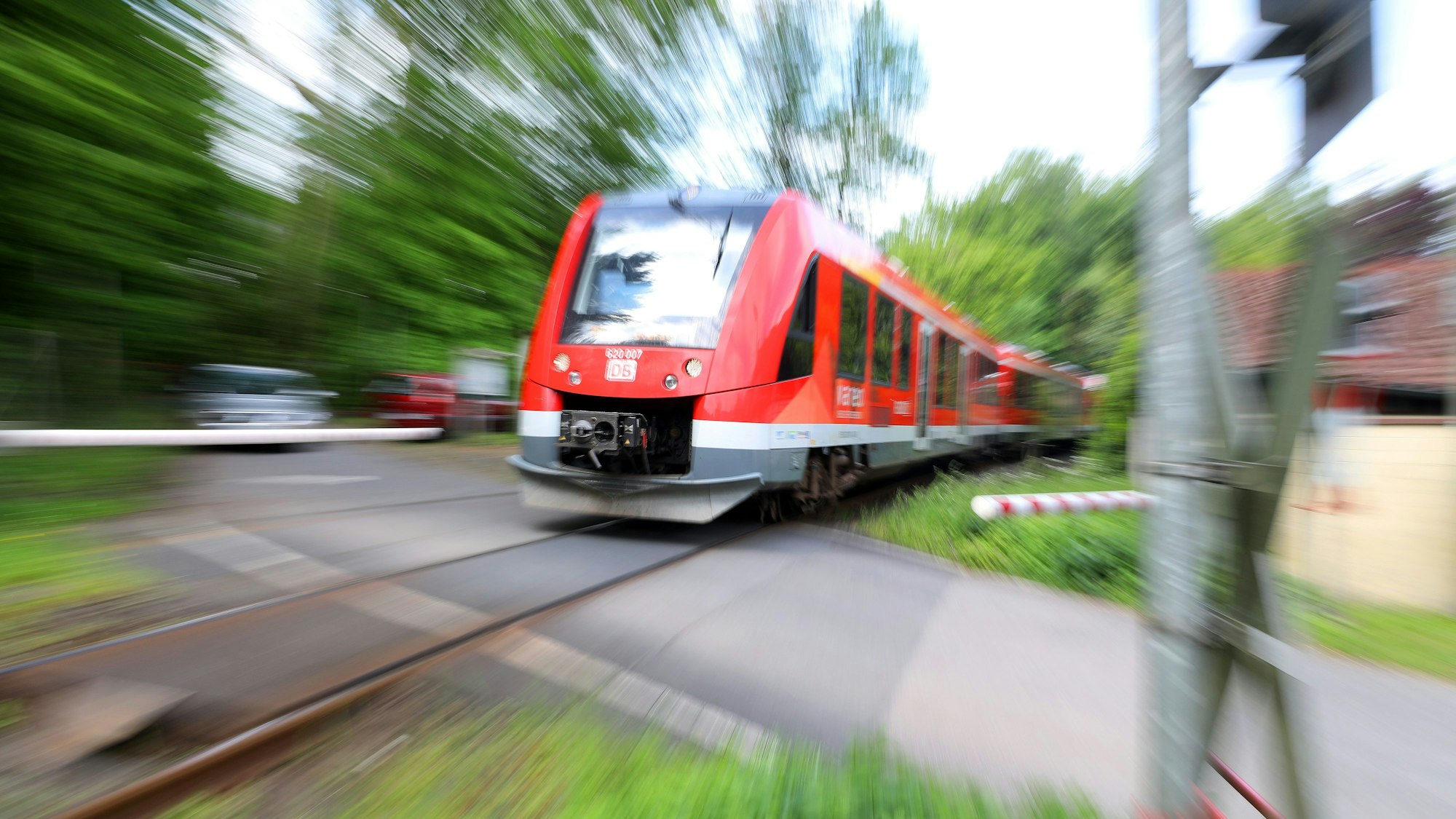 Eine Regionalbahn fährt über einen Bahnübergang bei Rösrath-Hoffnungsthal.