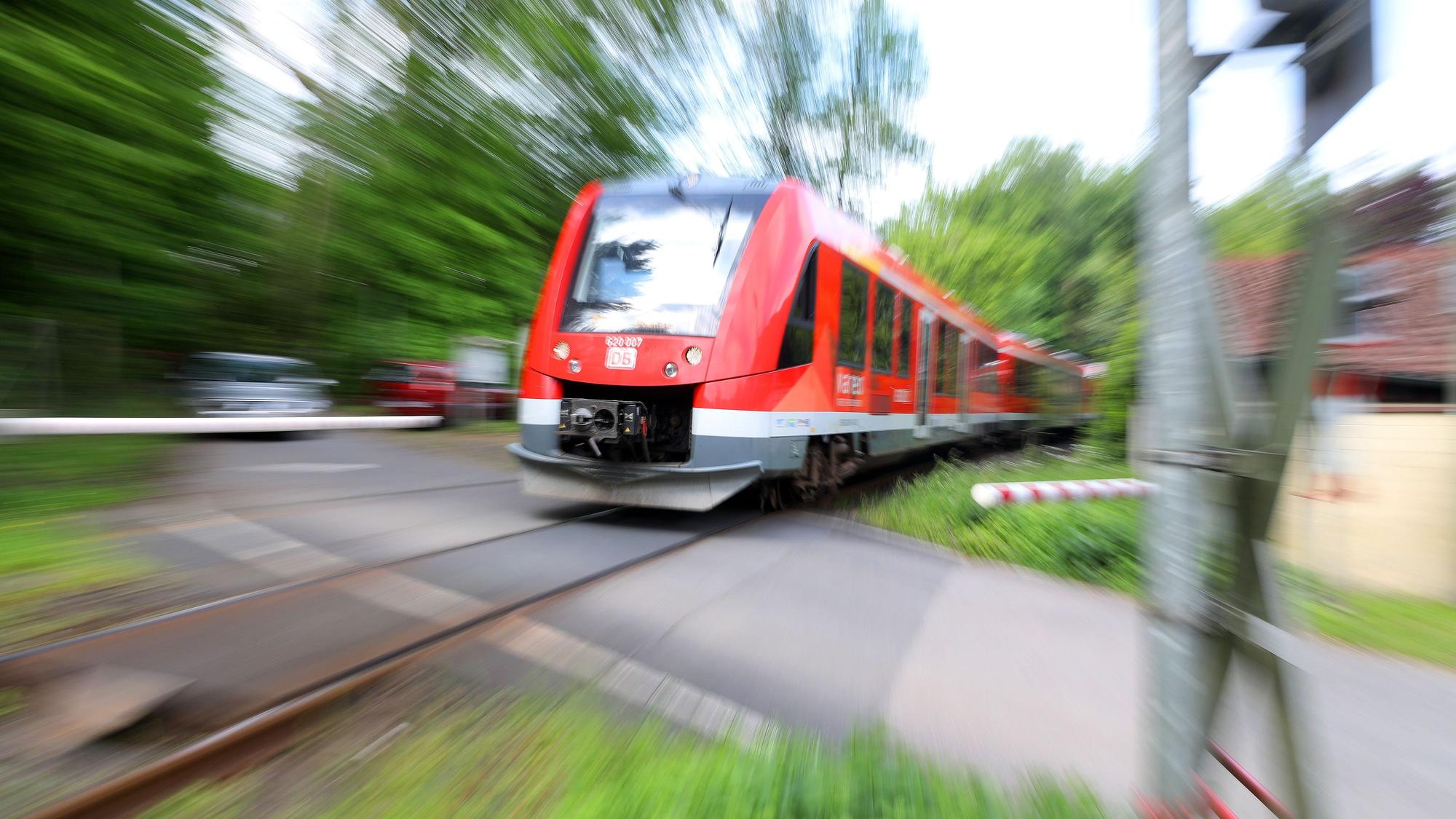 Eine Regionalbahn fährt über den Bahnübergang Brünsbacher Weg bei RösrathHoffnungsthal.