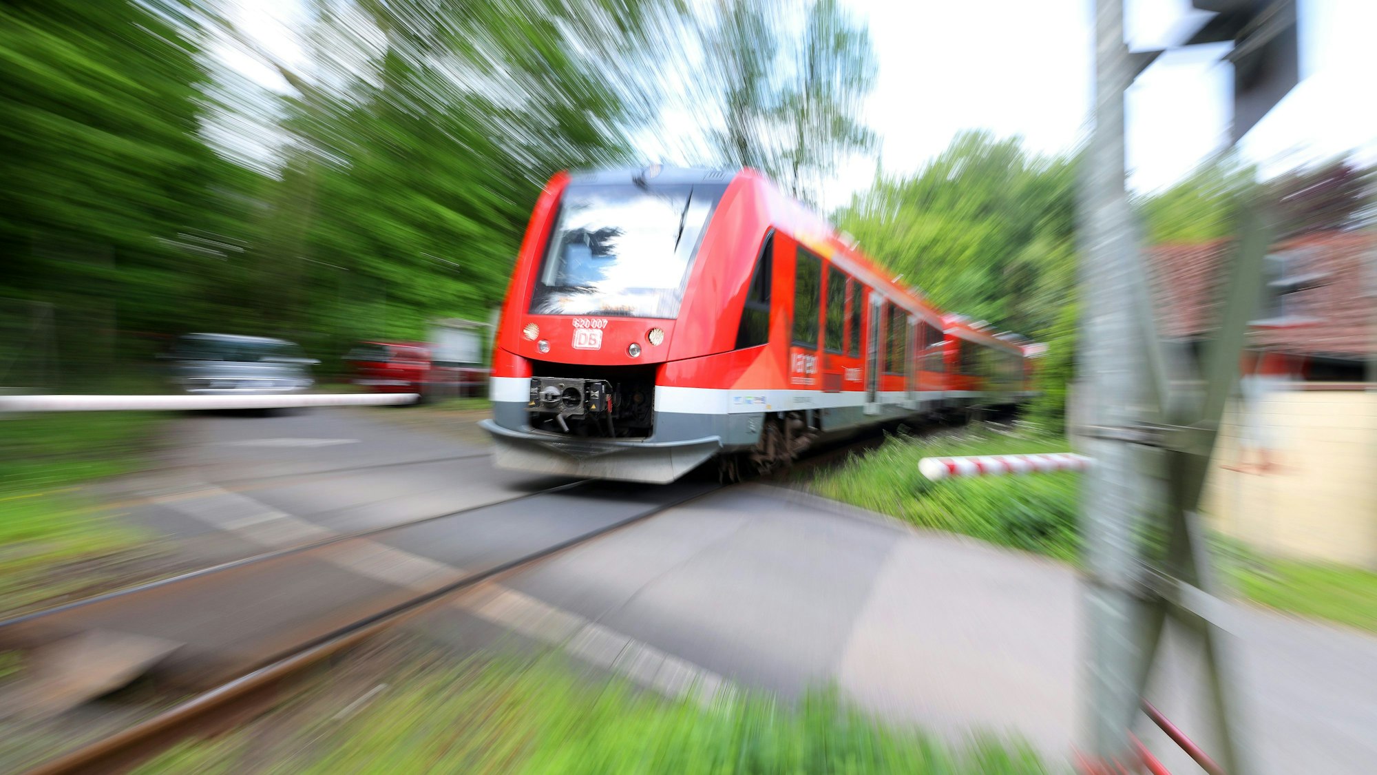 Eine Regionalbahn fährt über den Bahnübergang Brünsbacher Weg bei RösrathHoffnungsthal.